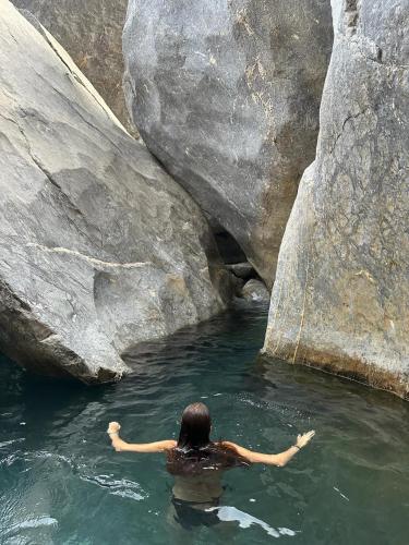 a person swimming in a pool of water near rocks at Hotel Golden Star in Taounate