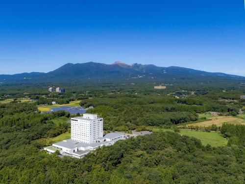 an overhead view of a white building in the woods at Grand Mercure Nasu Highlands Resort & Spa in Nasu