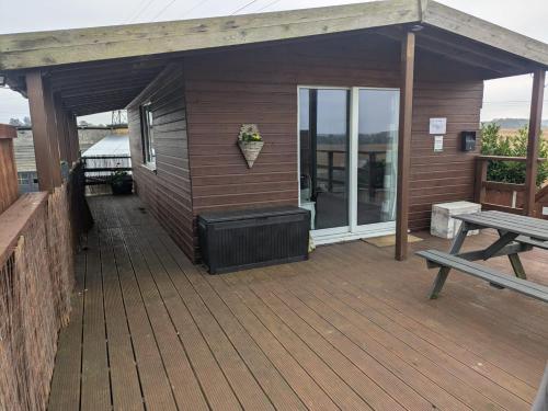 a wooden deck with a grill and a picnic table at The Viewpoint in Deal