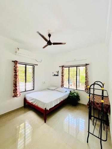 a bedroom with a bed and a ceiling fan at Marari Eden Castle in Vayalār