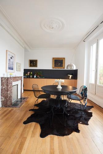 un salon avec une table et des chaises et une cheminée dans l'établissement Suite haussmannienne en Sologne, à Vierzon