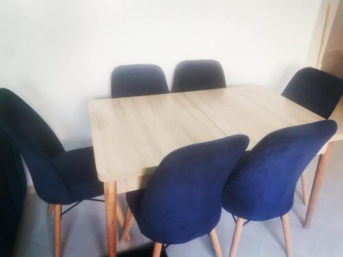 a wooden table with four blue chairs around it at Sable d'or in El Harhoura