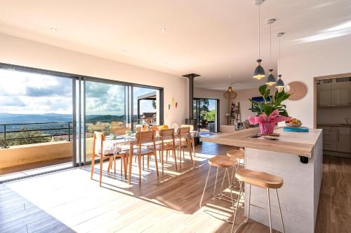 une cuisine et une salle à manger avec une table et des chaises dans l'établissement Maison Altea - Maison climatisée, à Figari