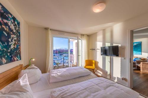 ein Hotelzimmer mit einem Bett und einem großen Fenster in der Unterkunft Hafenperle - Apartment mit Balkon & Wellnessbereich in der Hafenresidenz in Waren (Müritz)