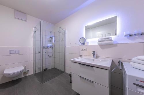 ein Badezimmer mit Toilette, Waschbecken und Dusche in der Unterkunft Hafenperle - Apartment mit Balkon & Wellnessbereich in der Hafenresidenz in Waren (Müritz)