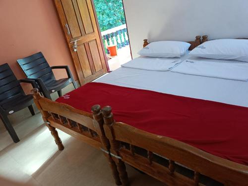 ゴカルナにあるShreekrishna iWOODS HOMESTAYの赤い毛布が掛けられた大きなベッドのある寝室