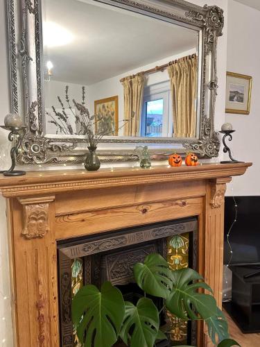 a mirror over a fireplace with pumpkins on it at Holly Tree Cottage in Glastonbury in Glastonbury