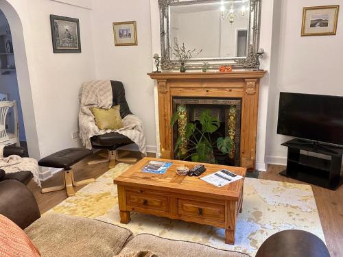 a living room with a coffee table and a fireplace at Holly Tree Cottage in Glastonbury in Glastonbury