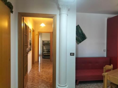 a hallway with a red couch and a pole at Zopito's House by Holiday World in Loreto Aprutino