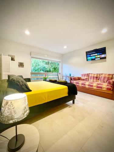 a bedroom with a large yellow bed and a couch at Villa Rose Marie Calme et Grands Espaces in Le François