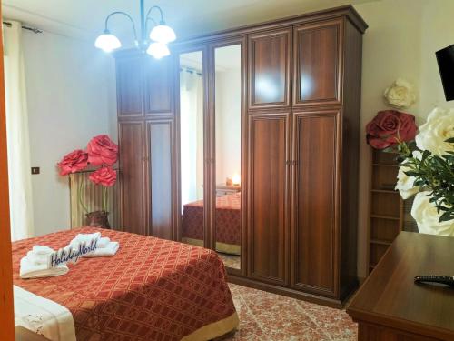 a bedroom with a bed and a large wooden cabinet at Zopito's House by Holiday World in Loreto Aprutino