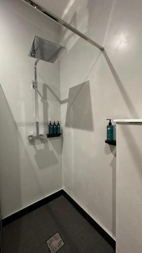 a bathroom with a white wall with bottles on shelves at Sweeney's Hotel 2020 Limited in Dungloe