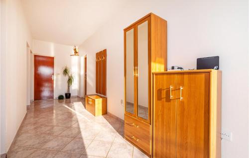 a hallway with a wooden cabinet and a mirror at 3 Bedroom Amazing Apartment In Jasenice in Jasenice