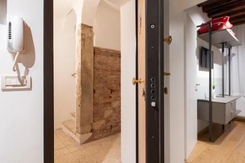 a hallway with a door and a brick wall at Cavalletto Suite in Venice