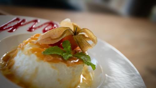 a white plate topped with a piece of food at Hôtel Nell in Saint-Marcel