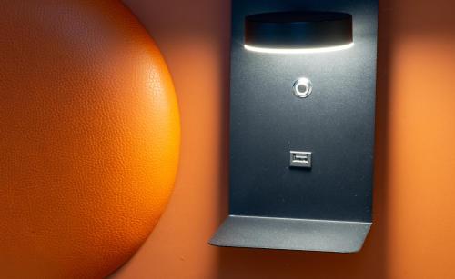a close up of a cell phone and an orange at Hôtel Nell in Saint-Marcel