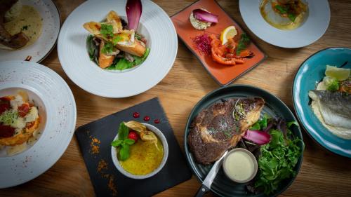 a table topped with plates of food and bowls of food at Hôtel Nell in Saint-Marcel