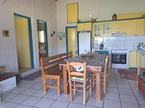 a kitchen with a wooden table and chairs in it at Dionisios in Kástro Tornéze