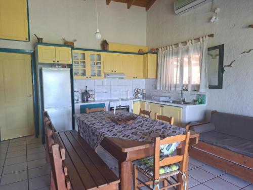a kitchen with a table and a kitchen with yellow cabinets at Dionisios in Kástro Tornéze