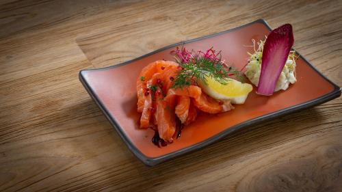 a plate of food with vegetables on a table at Hôtel Nell in Saint-Marcel