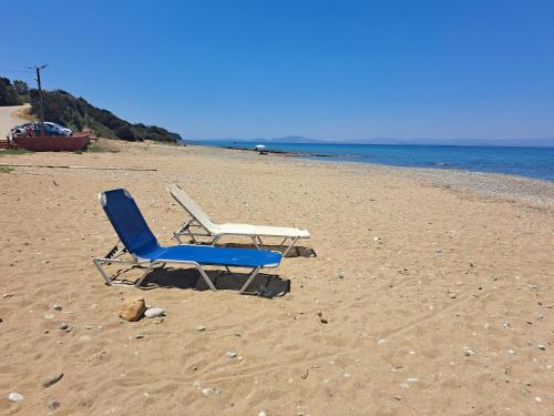 a blue and white chair sitting on a beach at Dionisios in Kástro Tornéze