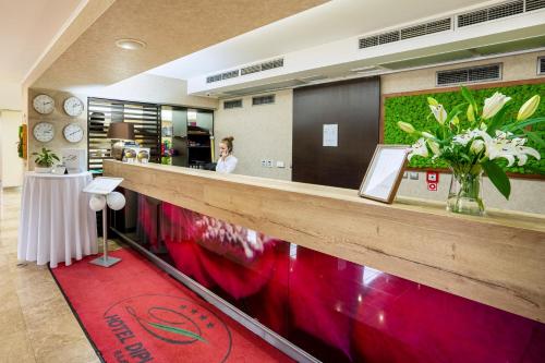 a woman standing at the counter of a restaurant at Wellness Hotel Diplomat in Rajecké Teplice