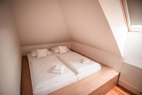 a small room with a bed in a attic at Penzion Panský dvůr Telč in Telč