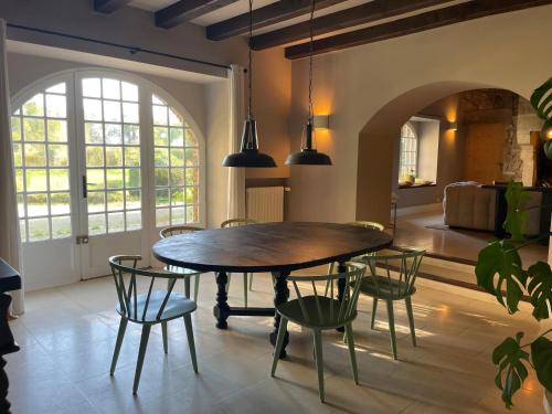 a dining room with a wooden table and chairs at Château Doré les Tours - Appartement Loup in Montfaucon