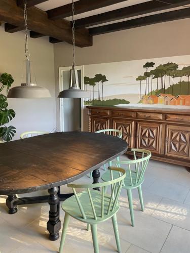 a dining room with a wooden table and chairs at Château Doré les Tours - Appartement Loup in Montfaucon
