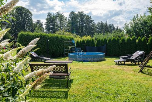 a backyard with a pool and a table and chairs at Penzion Dolíček in Cheb