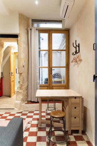 une cuisine avec une table et une chaise dans une pièce dans l'établissement L'ARLSTUDIO Centre-ville Arles, à Arles