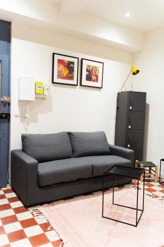 un salon avec un canapé et une table dans l'établissement L'ARLSTUDIO Centre-ville Arles, à Arles