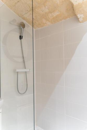 une douche avec une porte vitrée dans une salle de bain dans l'établissement L'ARLSTUDIO Centre-ville Arles, à Arles