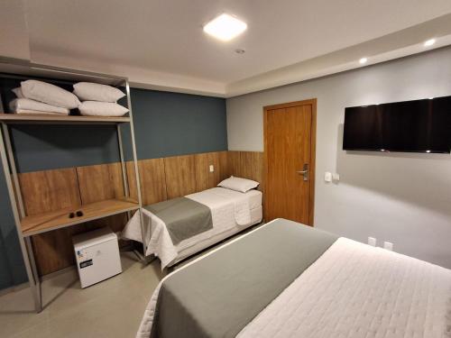 a hotel room with a bed and a television at Pousada Infinity Gasthaus in Pomerode