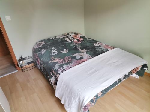 Ce lit se trouve dans un dortoir doté d'une couverture fleurie. dans l'établissement Appartement 2 pièces Obernai proche centre ville, à Obernai