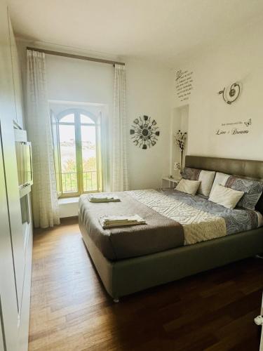 a bedroom with a large bed and a window at LA DOGANA . in Siena