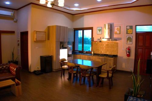 a kitchen and dining room with a table and chairs at AkiraSunRice Villa calme, jardin et rizières in Phra Nakhon Si Ayutthaya