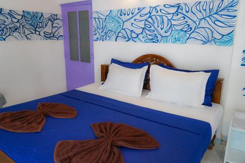 a bedroom with a blue and white bed with two pillows at Singhe House in Dickwella