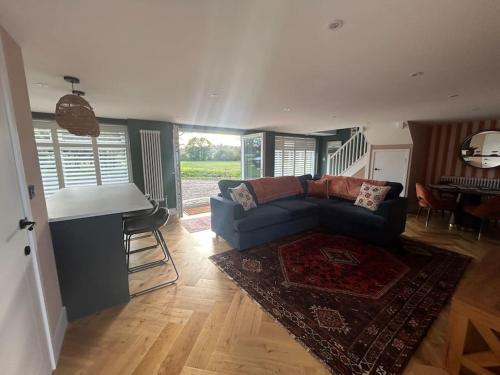 a living room with a couch and a piano at Spitfire View in Aldington