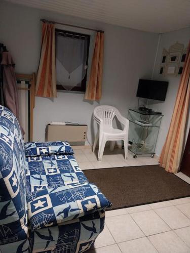 une chambre avec un lit, une chaise et une fenêtre dans l'établissement un coin tranquille, aux Mathes