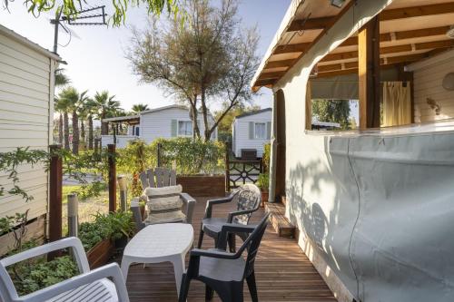 d'une terrasse avec des chaises et des tables. dans l'établissement Chez Hervé, à Hyères