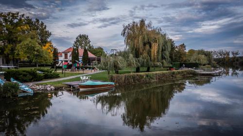 a river with boats in the middle of it at Hercegasszony Birtok in Mezőtúr
