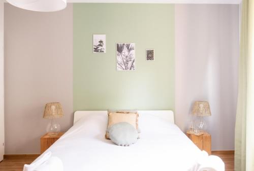 a bedroom with a white bed with two lamps at Le Luminosa - Centre Ville - 6 pers in Haguenau