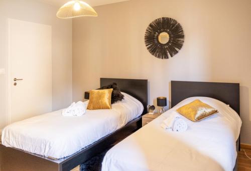 a bedroom with two beds and a mirror on the wall at Le Luminosa - Centre Ville - 6 pers in Haguenau