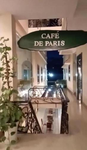 un immeuble avec une enseigne Café de Paris sur un balcon dans l'établissement Le Petit Paris Dalat Hotel, à Đà Lạt