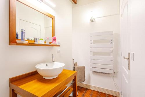 une salle de bain avec un lavabo blanc et un miroir dans l'établissement Cottage au calme avec terrasse et jardin, à Villegouge