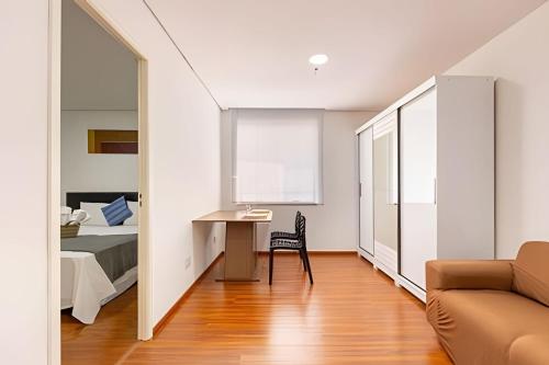 a room with a bed and a desk and a couch at Flats Osasco Trade Center in Osasco