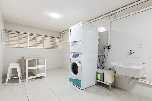 a laundry room with a washing machine and a sink at Flats Osasco Trade Center in Osasco
