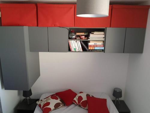 - une chambre avec des armoires rouges et un lit avec des oreillers rouges dans l'établissement T2 Les pieds dans l'eau, à Arcachon