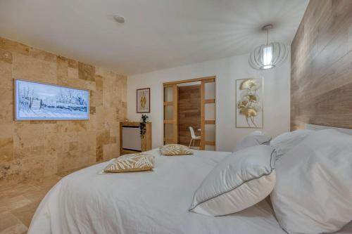 a bedroom with a large white bed with pillows at Appartement luxueux avec jacuzzi in Saint-Martin-dʼHères